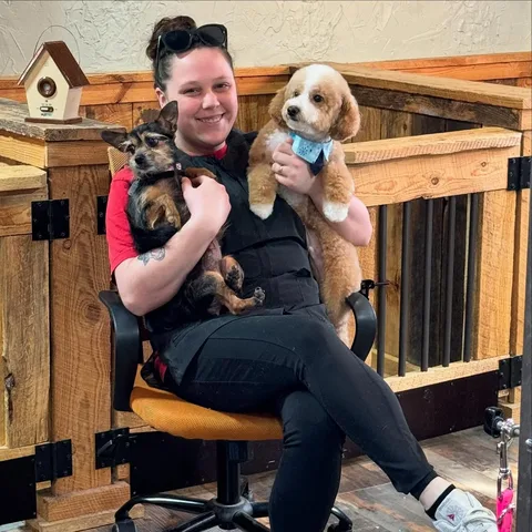 Best Friendz Too groomer caring for two dogs in the Winston-Salem salon